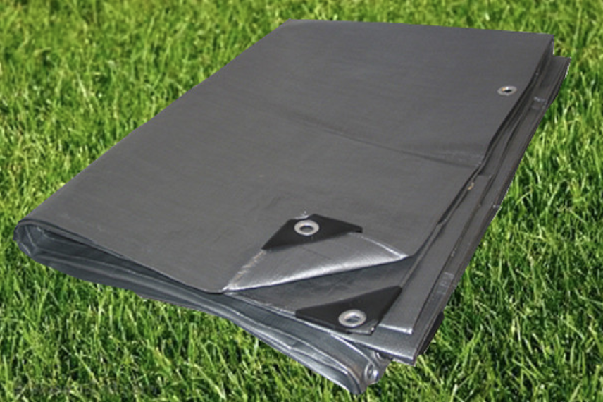 Heavy-duty gray waterproof tarp with reinforced corners and metal grommets on grass.